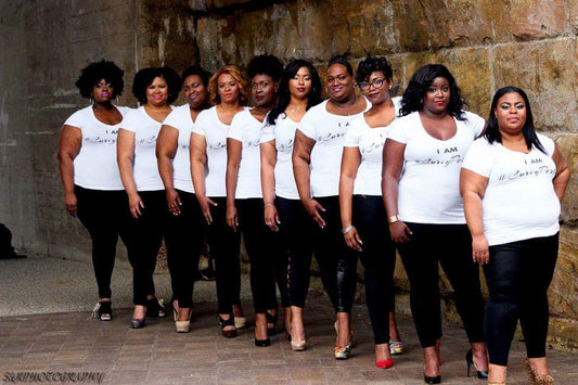 Group of confident plus-size women standing in a row wearing I Am #CurvyPerfect shirts, representing unity, empowerment, and body positivity.